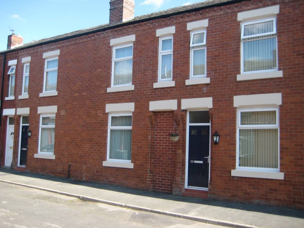 White casement windows on a red brick terraced property